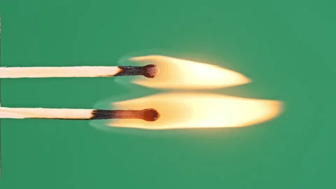 Vertical Two Match Sticks Ignites and Burns on a Green Background Close-Up Stock-Footage 329628080