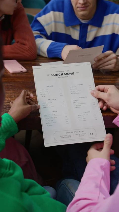 Vertical of Two Multiethnic Friends Reading Lunch Menu while Visiting Cafe Stock Footage 333263372