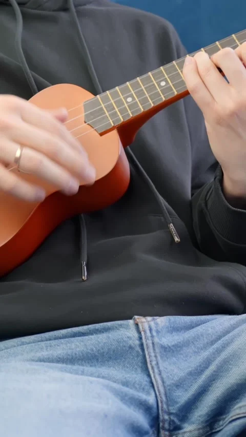 Vertical Ukulele Playing Indoors With Hand Plucking Strings Stock Footage 309567080