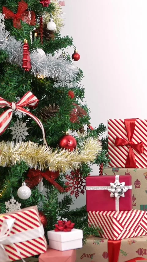 Vertical Under a modern Christmas tree, elegantly wrapped gift boxes enhance  Stock Footage 315237292