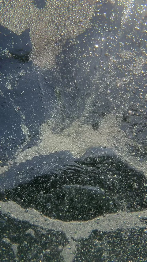 Vertical underwater view of air bubbles and tiny particles drifting through seaw Stock Footage 339279421