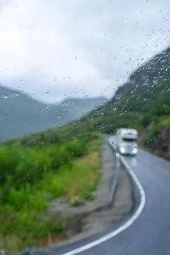 Vertical unfocused view through rainy glass of road in mountains in summer Foto stock