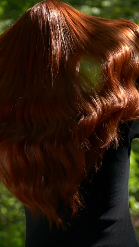 Vertical of unrecognizable female model with long red curly hair in slow motion Stock Footage 284799203