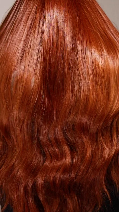 Vertical unrecognizable female model with long red curly hair in slow motion Stock Footage 311793134