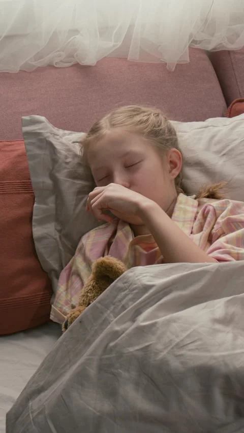 Vertical of Unwell Gen Alpha Child in Pajamas Sleeping in Bed with Soft Bear Stock Footage 335620213
