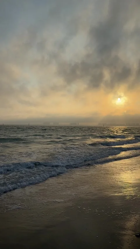 Vertical Vibrant Red Sunset over Ocean Waves with City Skyline 4K Stock Footage 331897184