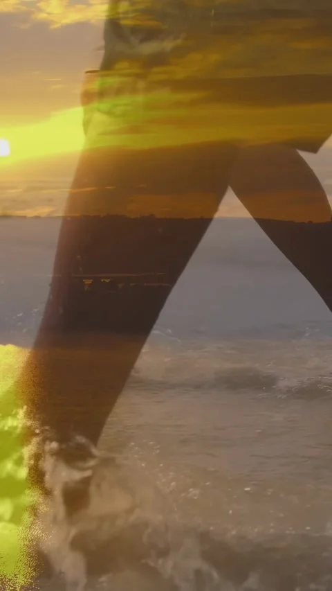 Vertical video: 2 men walking sunset travel together stepping into surf causing Stock Footage 330542966
