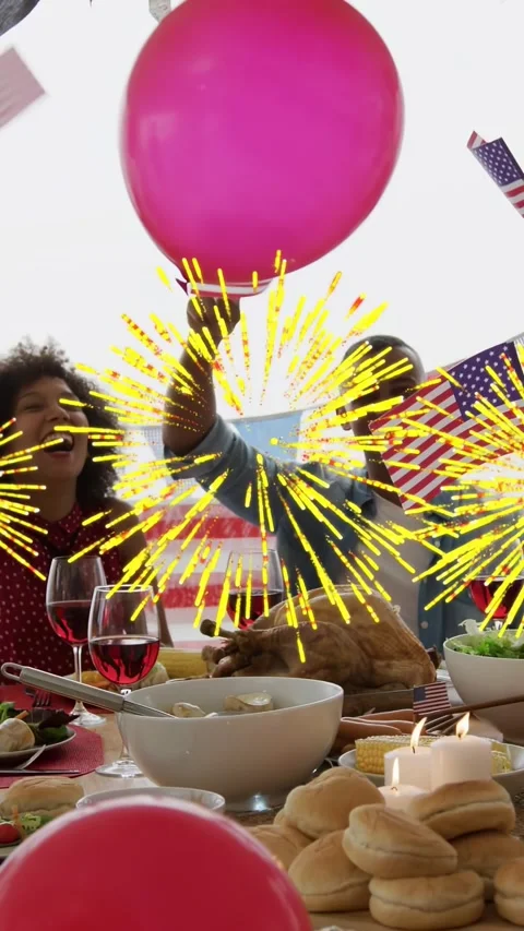 Vertical video: 2 seated at table waving flags as sparks flashing he lifting Stock Footage 334836934