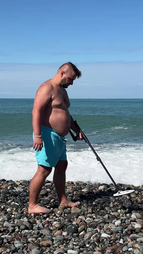 Vertical video. 60 fps. Treasure hunter on ocean coast Stock Footage 332808870