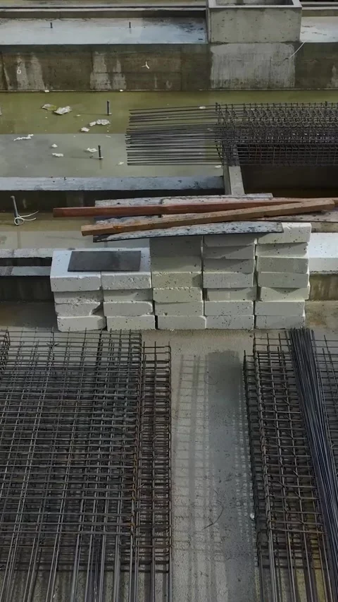 Vertical Video: Active building site with cranes and workers lifting materials Stock Footage 297634892