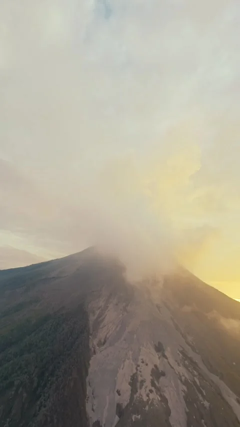 Vertical video. Active volcano eruption smoke stream gas sunrise bright sun sky Stock Footage 248386125