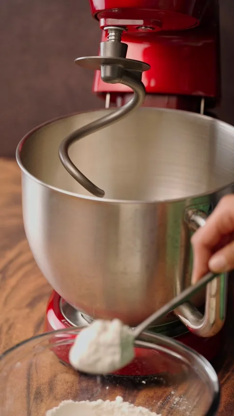 Vertical video, adding all-purpose flour by tablespoons to a bowl Stock Footage 282499589