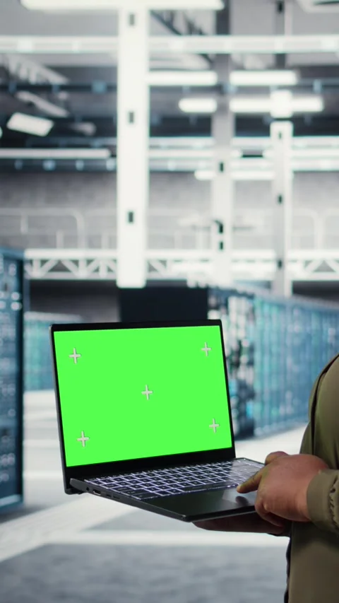 Vertical video Admin in data center uses green screen laptop to ensure error Stock Footage 316858551