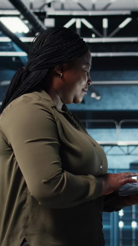 Vertical video Admin in data center using app on laptop to ensure error free Stock Footage 317055658