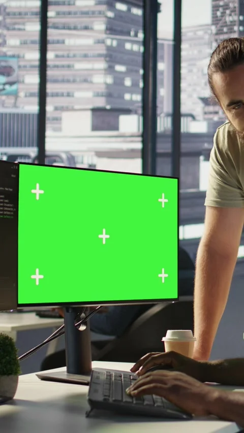 Vertical video Admin doing software debugging on green screen PC with colleague Stock Footage 319488919