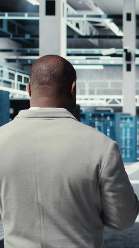 Vertical video Admin walking in high tech data center facility, checking Stock Footage 311417412
