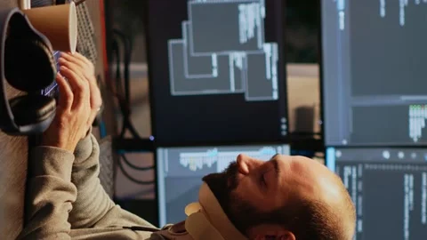 Vertical video: Adult programmer with neck collar foam coding html script Stock Footage 221872406