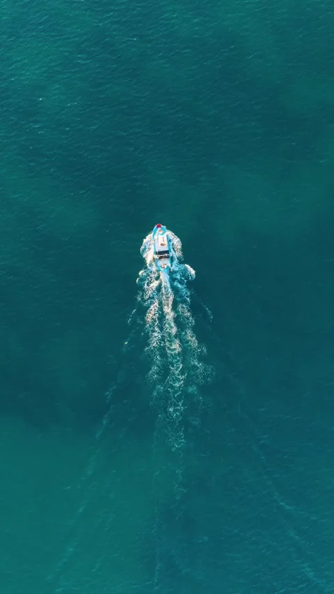 Vertical video. Aerial drone view of a fast motorboat in the blue ocean. Stock Footage 337344529