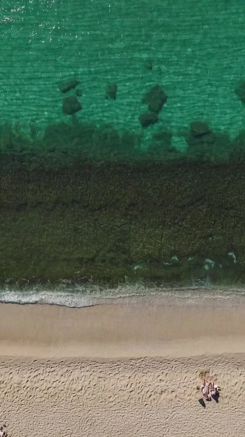 Vertical Video: Aerial Perspective of a Beach With Crystal Waters and a Stunning Stock Footage 300329801