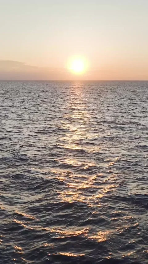 Vertical Video: Aerial Perspective of Ocean Texture Shimmering in Sunset Rays by Stock Footage 342590928