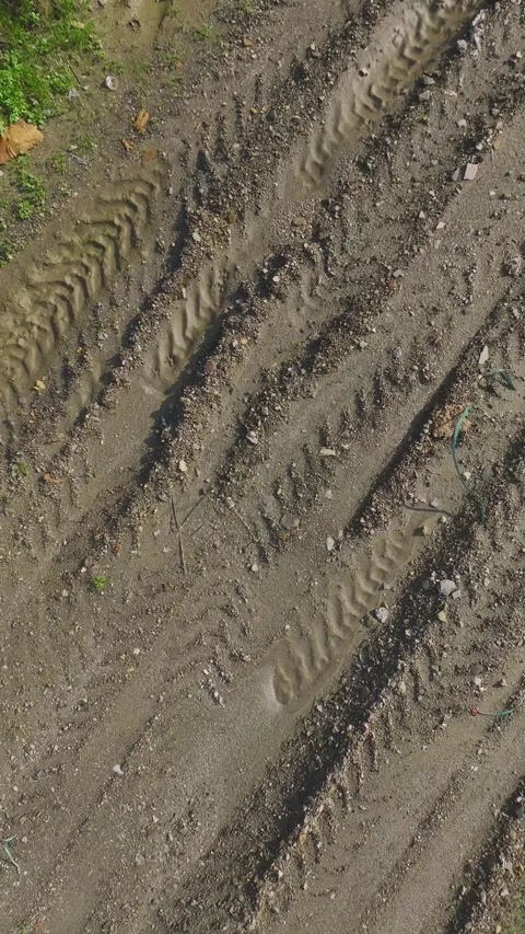 Vertical Video: Aerial Perspective of Tractor Tire Marks on Plowed Soil in a Stock Footage 342605203