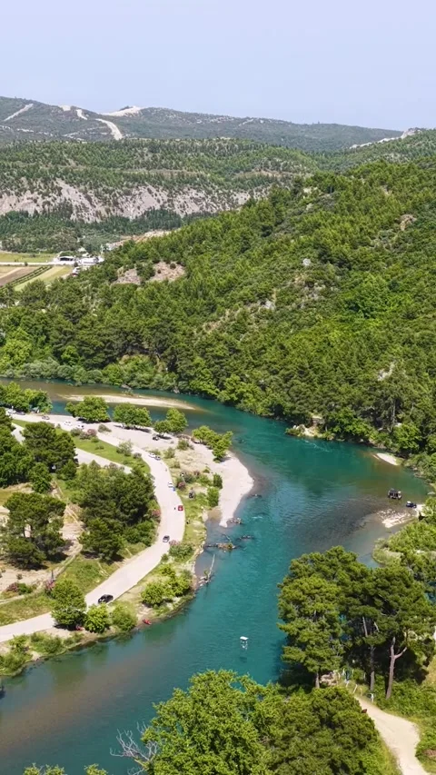 Vertical Video Aerial River Path Through Green Hills and Open Valley 库存影片 342079741
