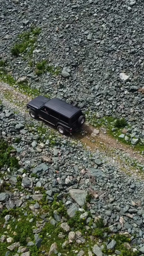 Vertical Video: Aerial Top Down Black SUV Driving on Mountain Road Video stock 331790589