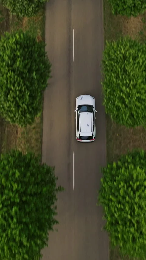 Vertical video. Aerial view of electrical car driving on country road at summer Stock Footage 271349751