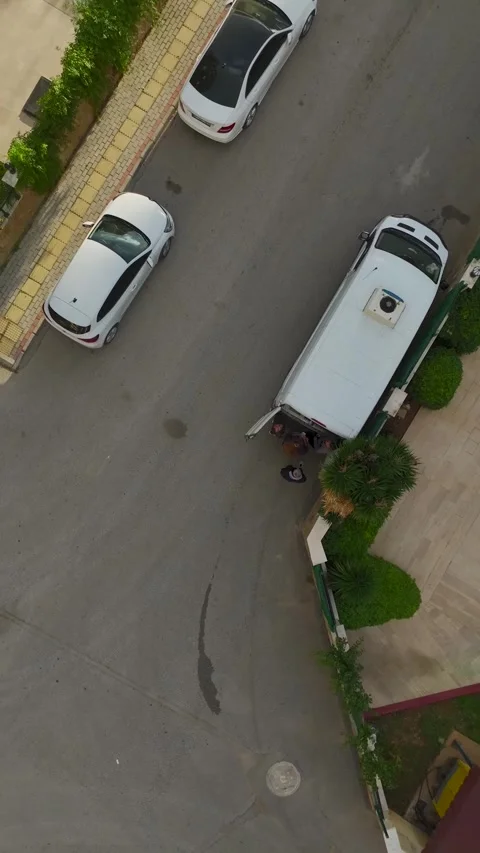 Vertical Video: Aerial view of illegal street trading as vendors set up goods in Stock Footage 297655678