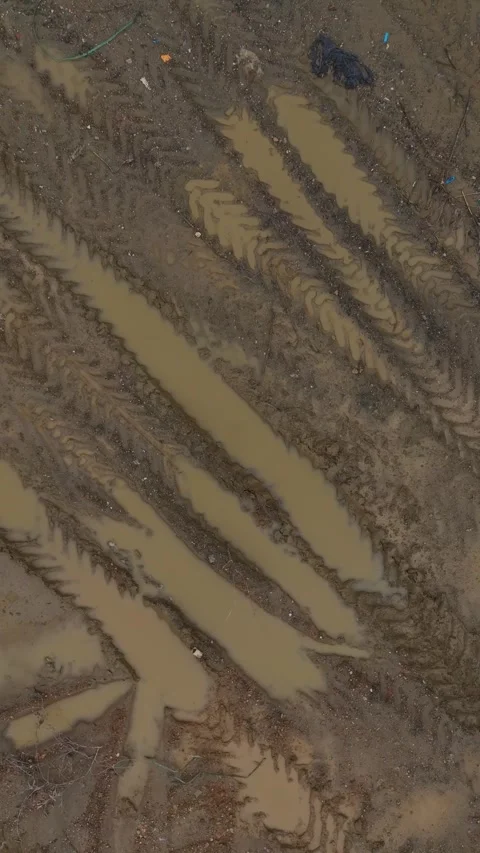 Vertical Video: Aerial View of Tire Tracks on Dry Ground Showing Vehicle Stock Footage 342574675