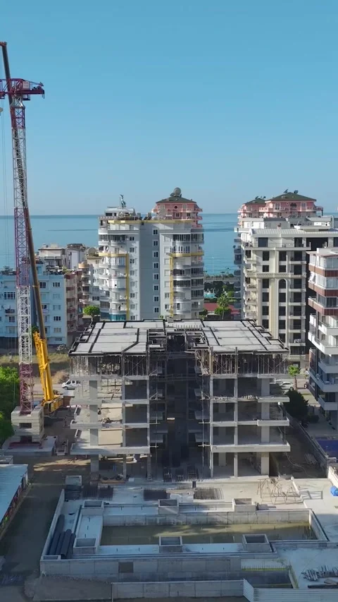 Vertical Video: Aerial View Of Workers Joining Large Crane Parts On A Vibrant Stock Footage 297708838