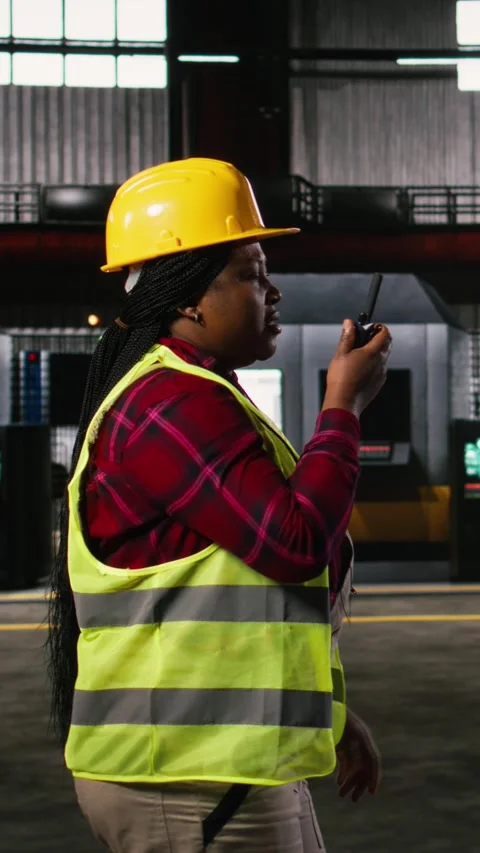 Vertical Video African american engineer speaks into walkie-talkie transmitter Stock Footage 330139050