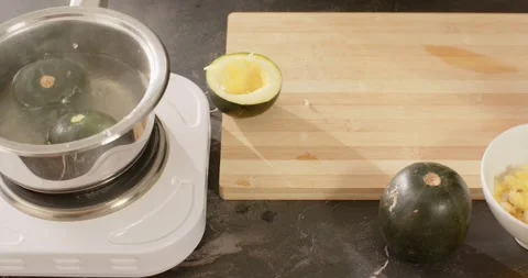 Vertical video: African American man scooping pulp, putting shells into pot for Stock Footage 340774342