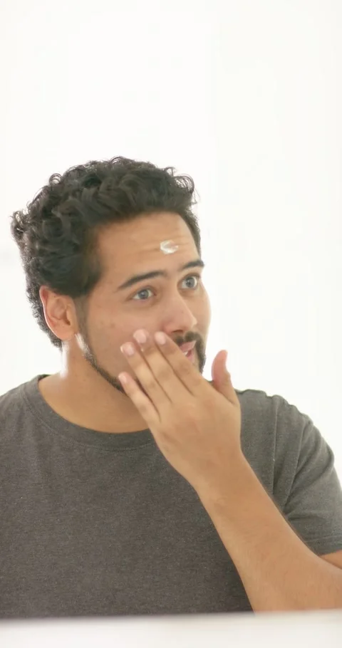 Vertical video: African American man at vanity rubbing cream on forehead Stock Footage 345397516