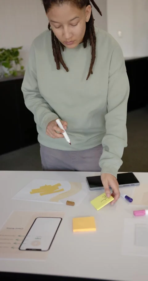Vertical video: African American nonbinary writing and aligning sticky notes on Stock Footage 344695550