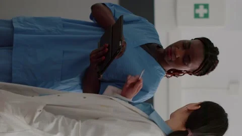 Black nurse writes notes with doctor in ... | Stock Video | Pond5