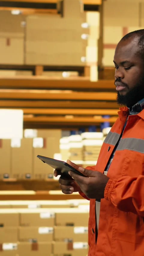 Vertical Video African american worker reviewing inventory data in warehouse Stock Footage 333089550