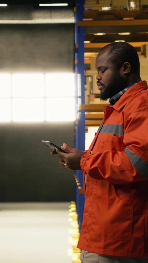 Vertical Video African american worker reviewing inventory data in warehouse Stock Footage 333090991