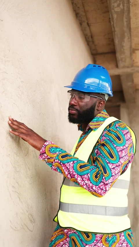 Vertical Video African construction engineer inspects plastered wall on site Stock Footage 347379314
