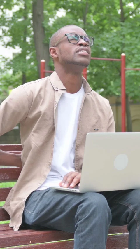 Vertical Video, African Man with Back Pain Using Laptop Outdoor on Bench Video stock 318043768