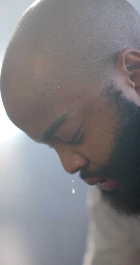 Vertical video: African man shaved head beard twitching eyelids opening eyes Stockbeeldmateriaal 345322169