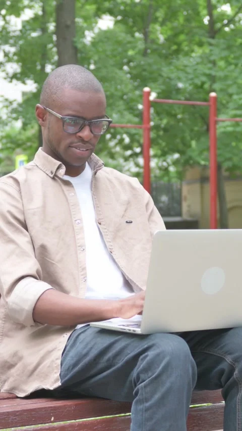 Vertical Video, African Man Using Laptop Outdoor on Bench Video stock 318043526