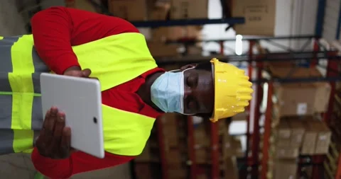 Vertical Video - African worker man using tablet inside warehouse Stock Footage 145434514