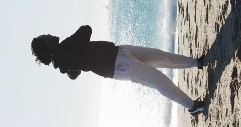 Vertical video of an afro man doing stretching on the beach Stock Footage 146951802