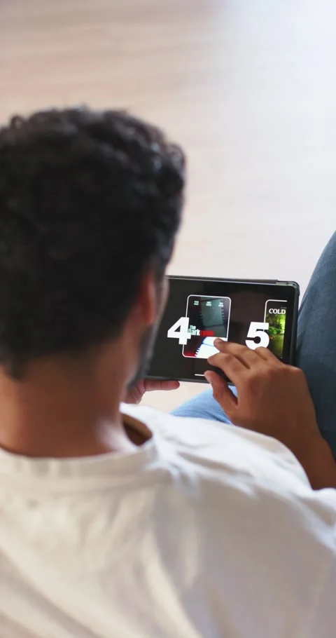 Vertical video: After 4,5 African American man swiping phone carousel on sofa Stock Footage 346719074
