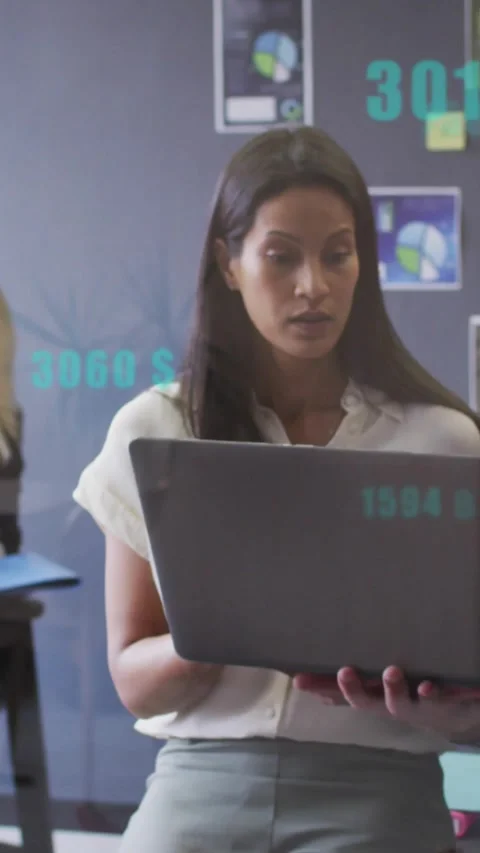 Vertical video: After peer cue, woman in white top holding laptop checking data Stock Footage 334550236