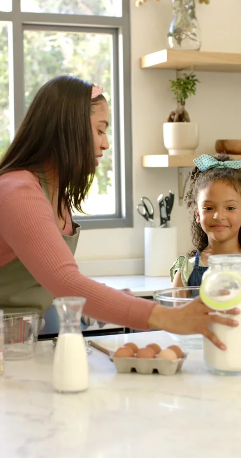 Vertical video: After positioning bowl on countertop, flour jar tilting over it, Video stock 345491853