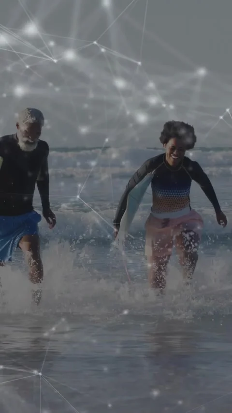 Vertical video: After wave breaks couple running from surf to shore as tech Stock Footage 331128416