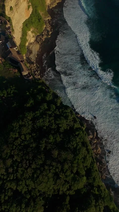 Vertical video. Aggressive FPV Drone Dive Along Karang Boma Cliff Above Ocean Br Stock Footage 336636519