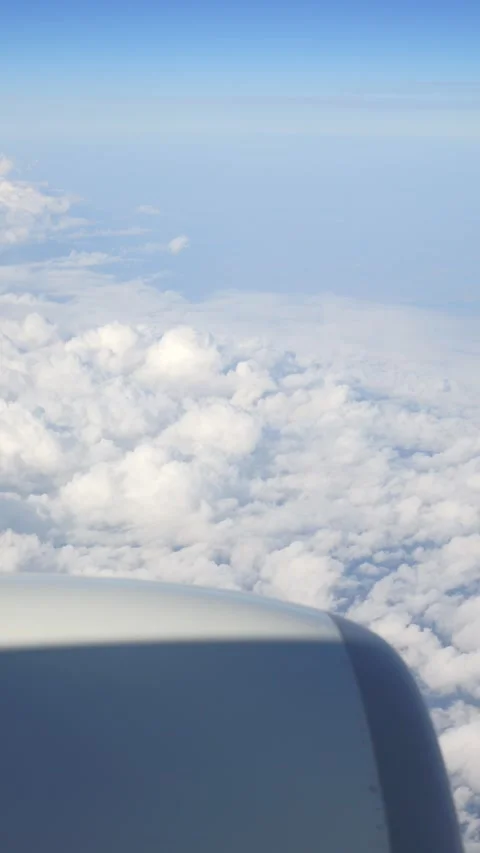Vertical video of airplane engine over a backdrop of clouds in a clear blue.. Stock Footage 294895740
